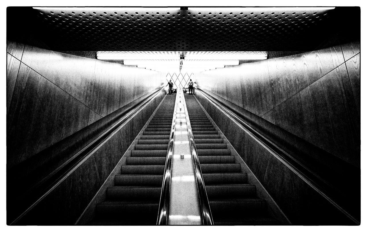 Symmetrical escalators in metro station, black and white