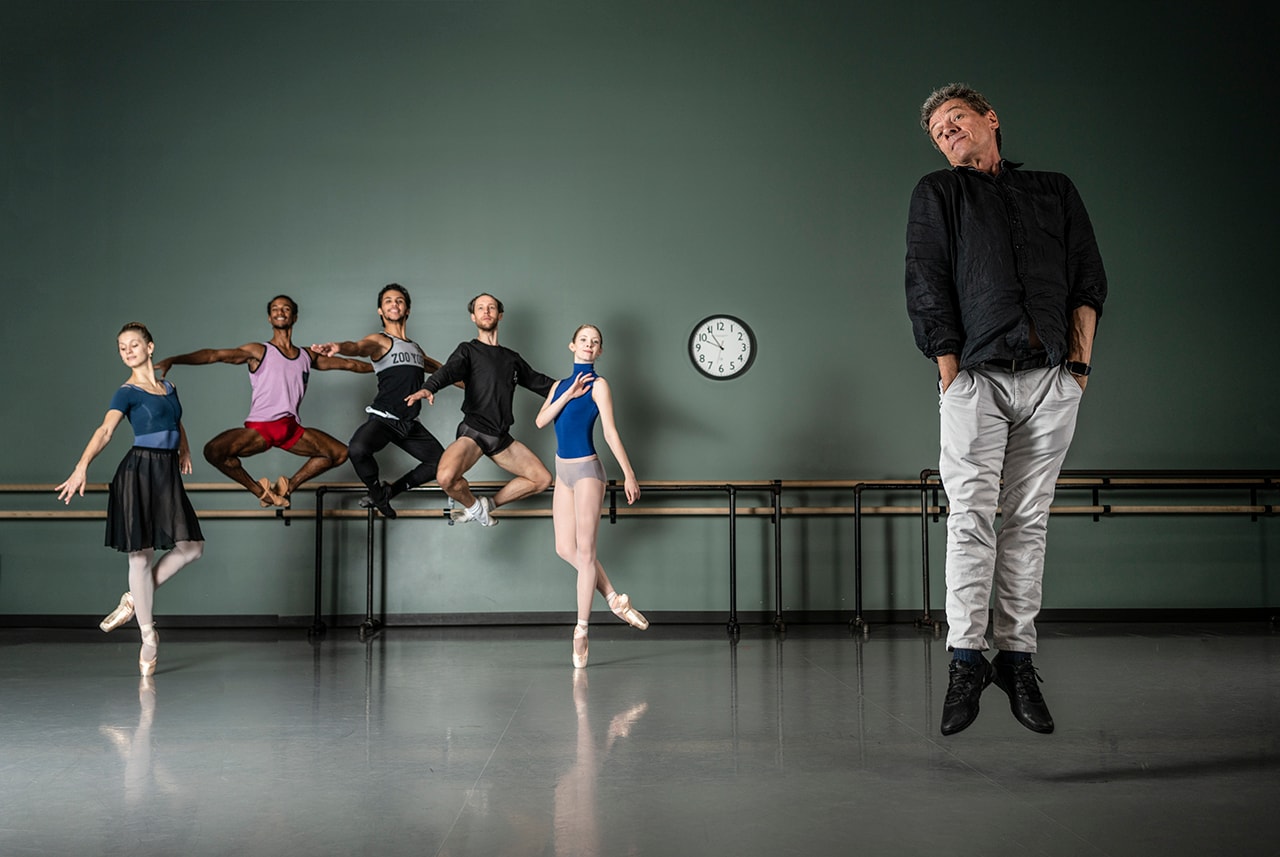 Ballet dancers and instructor jumping in rehearsal studio