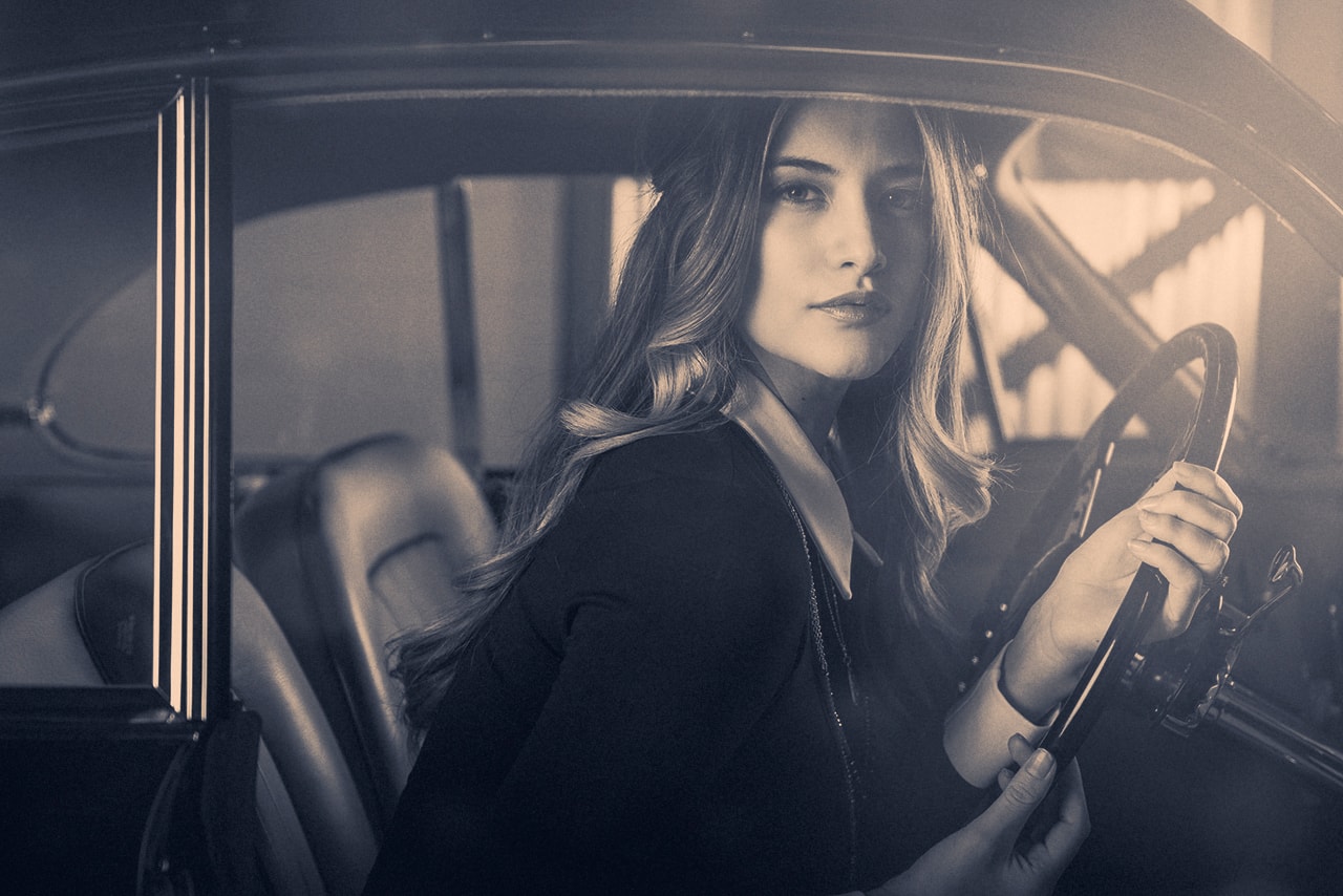 Woman in vintage car, cinematic fashion portrait
