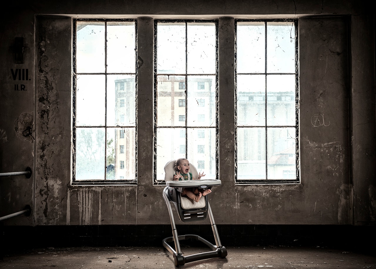 Baby in high chair in abandoned industrial space