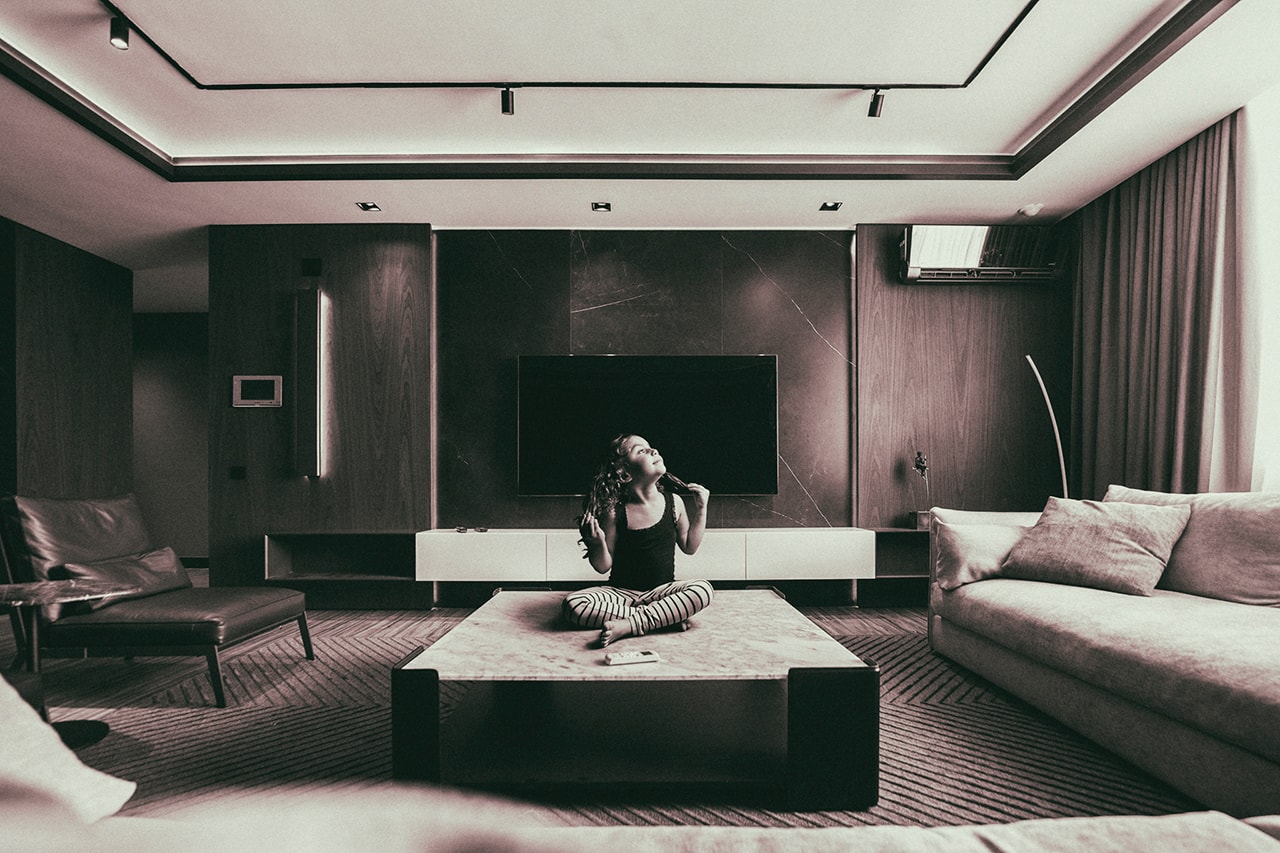 Girl sitting on coffee table in modern living room
