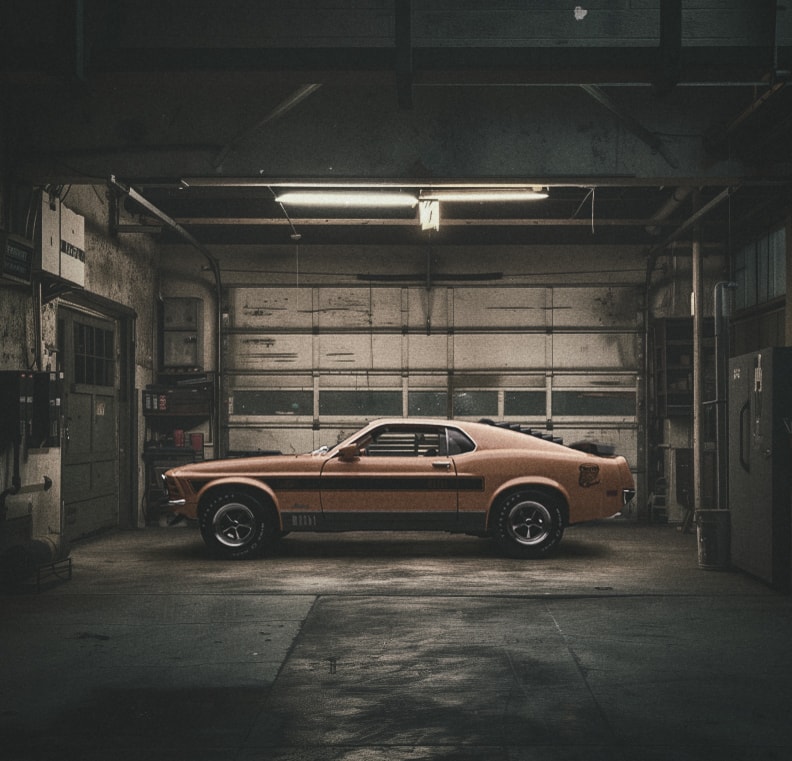 Copper orange vintage muscle car in a dark moody garage